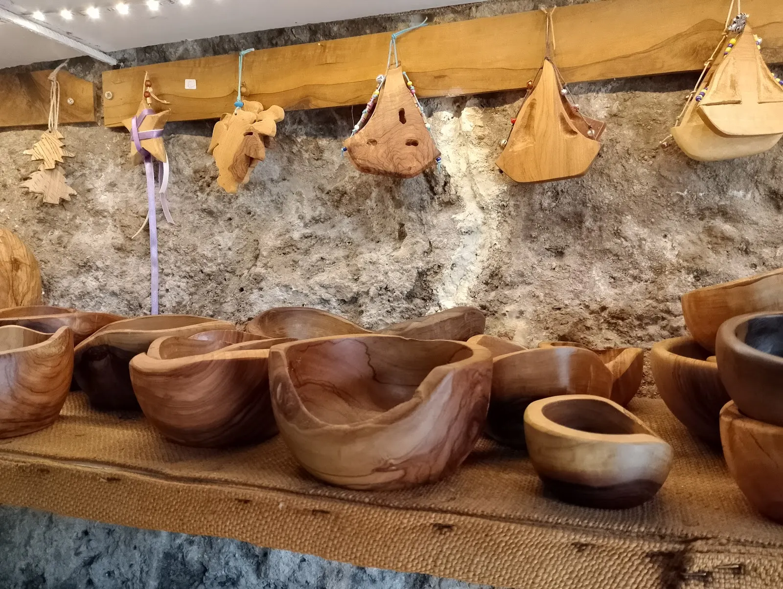 Rustic olive wood bowls on a stone wall shelf